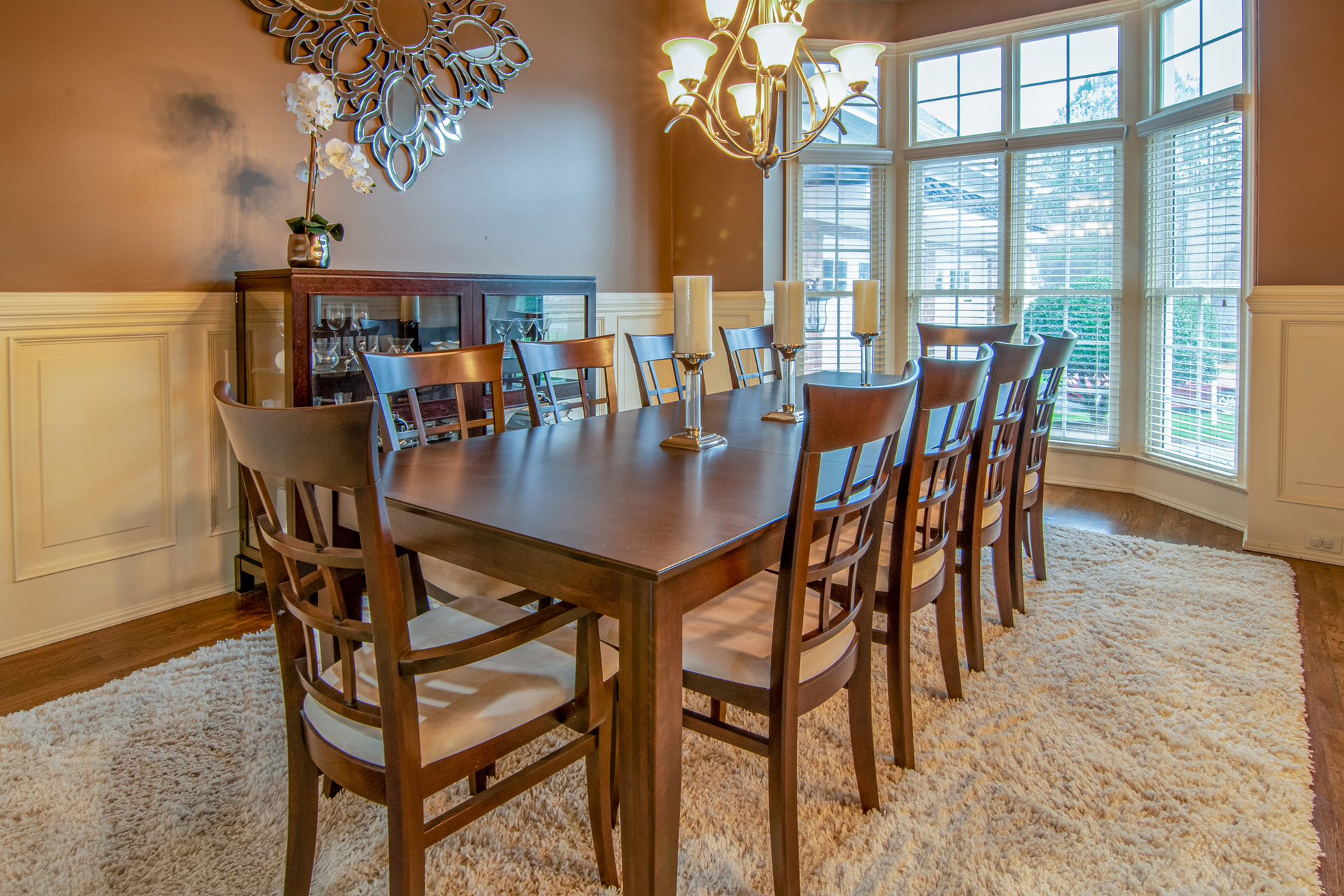 Spacious modern dining room with elegant wooden furniture and natural lighting.