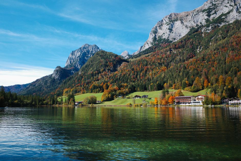 Picturesque autumn landscape of Hintersee Lake with vibrant foliage and majestic mountains in Germany.