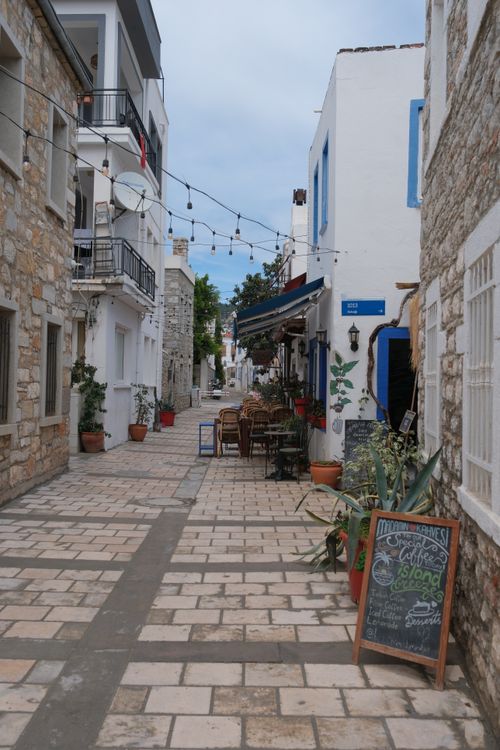 Free Quaint Mediterranean alley lined with cafes and string lights, perfect for a leisurely stroll. Stock Photo