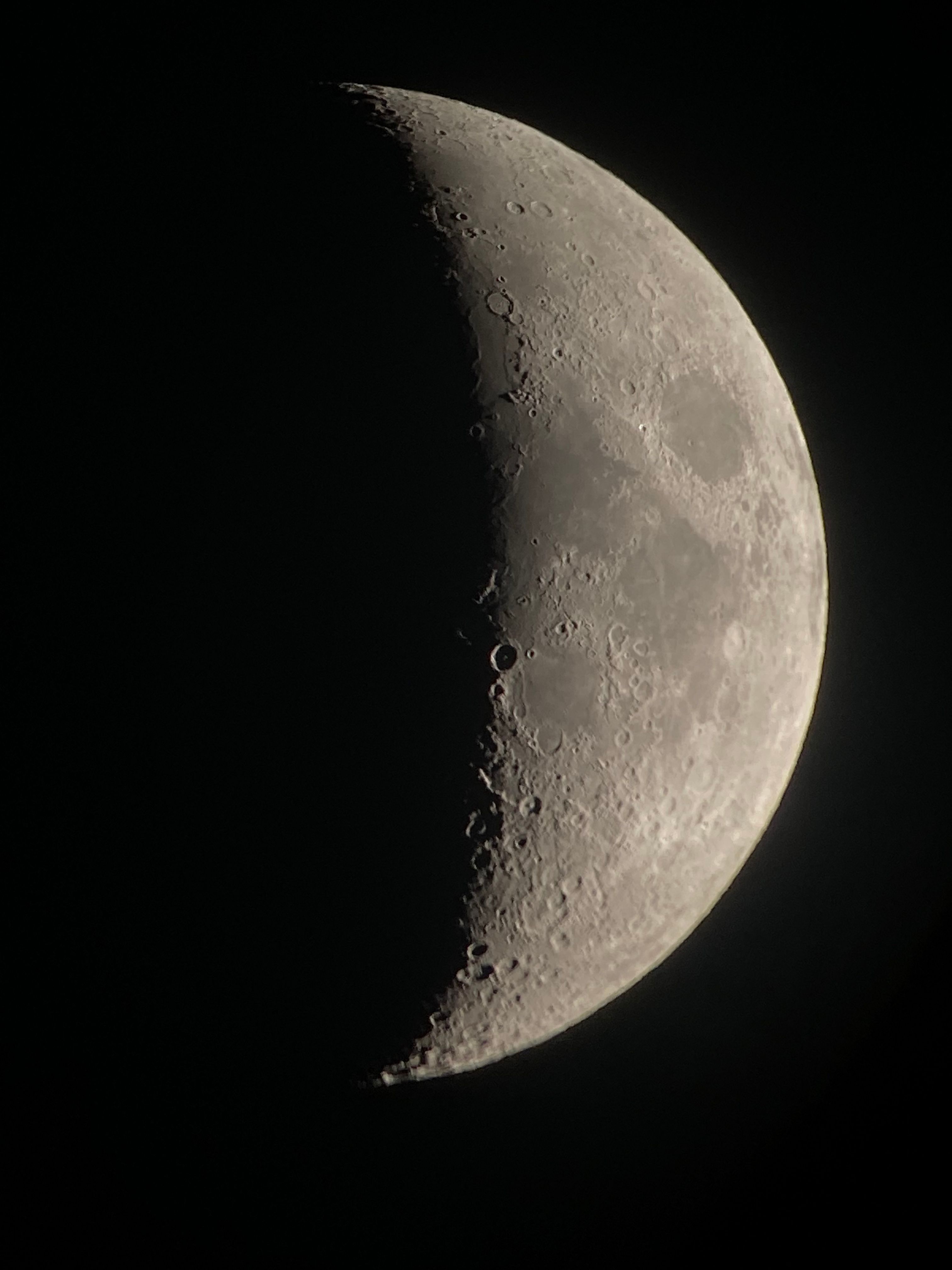 Close-up of a crescent moon showcasing detailed craters and shadows.