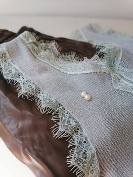 Close-up of lace-trimmed fabric featuring delicate pearl accents for a sophisticated look.