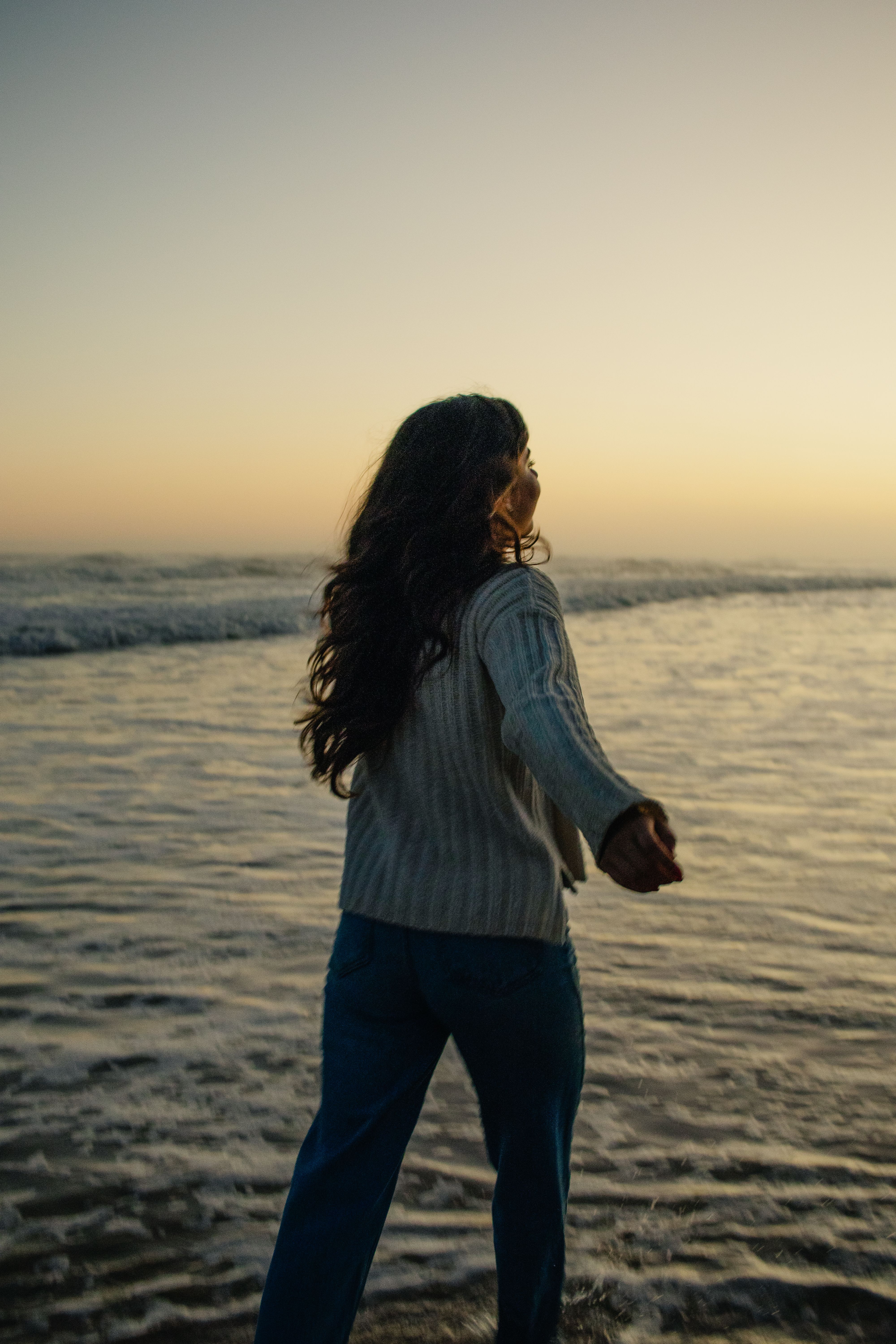 Woman Holding Camera at Sunset Beach · Free Stock Photo