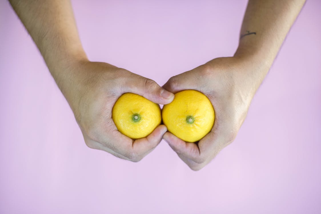 A person holding a couple of lemons.