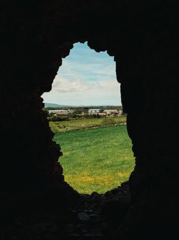 A picturesque view of the Rhuddlan countryside framed by ancient ruins.
