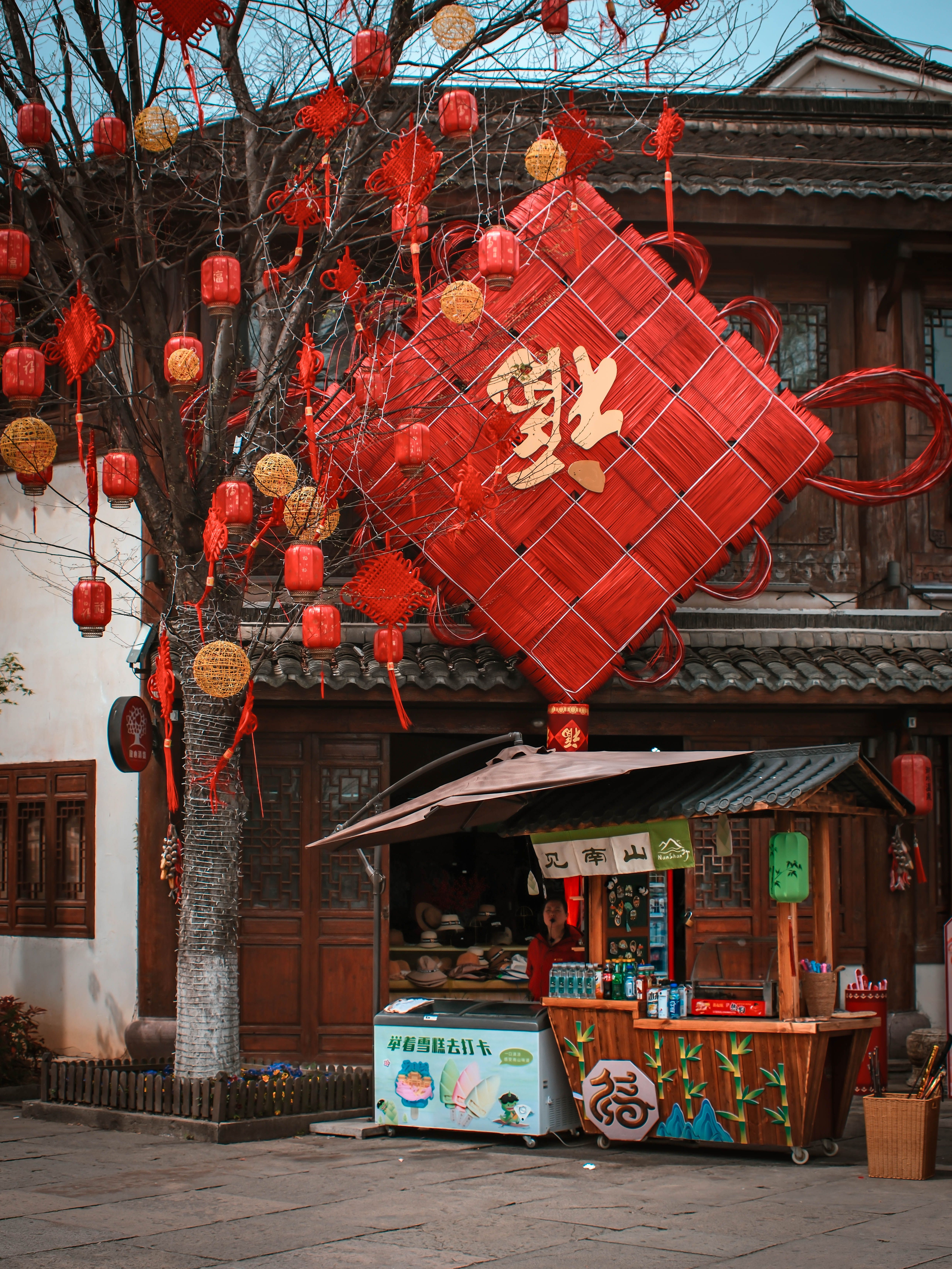 Colorful Chinese New Year street stand adorned with red lanterns and festive decorations.