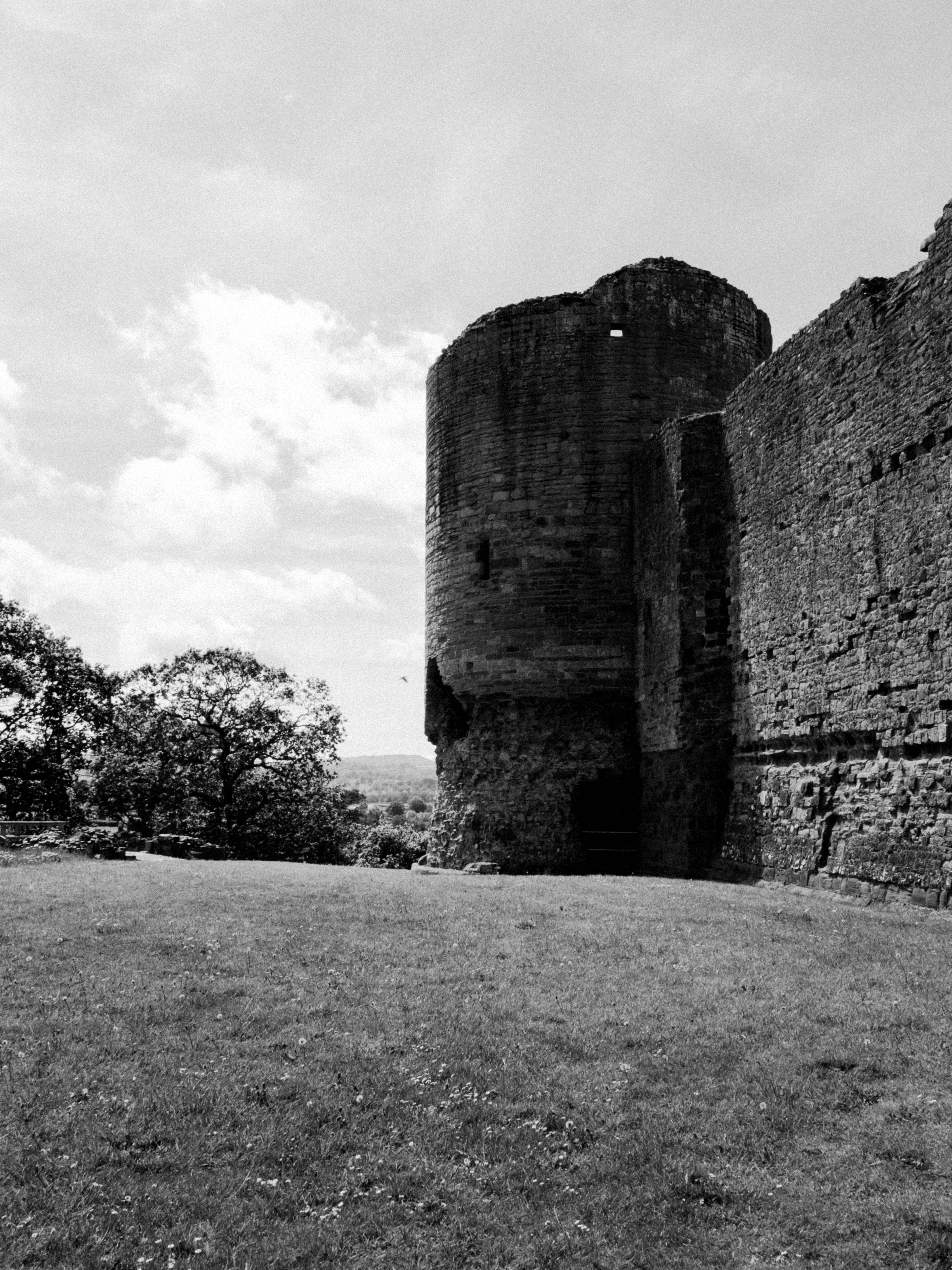 Black and white image of ancient castle ruins in Rhuddlan, showcasing medieval architecture.