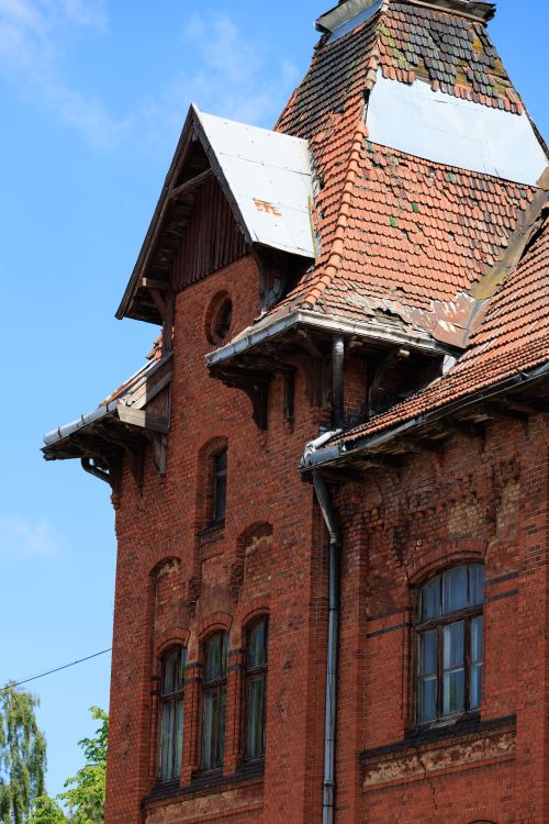 Historic brick commercial building with a damaged roof, where water intrusion begins