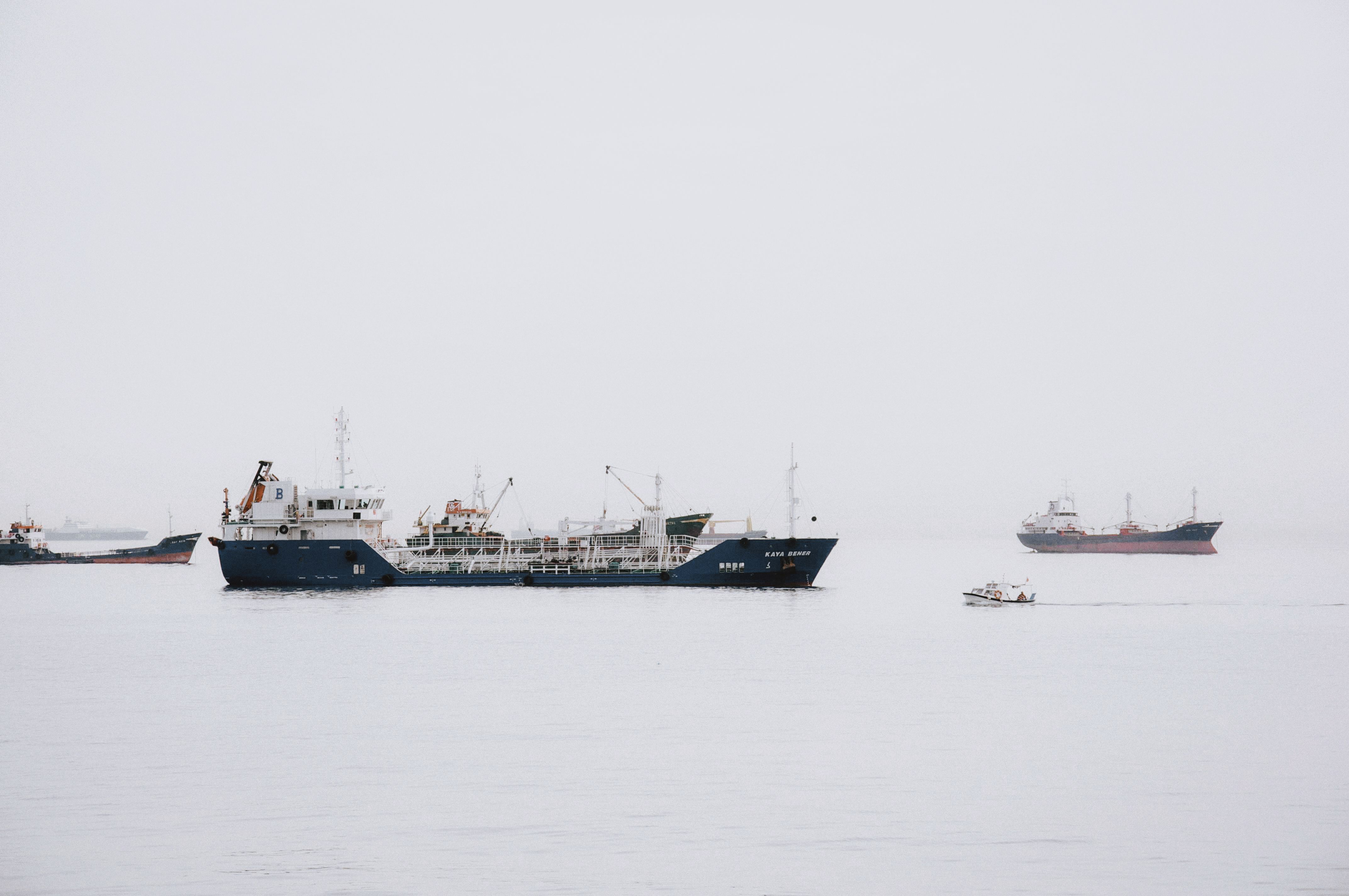 A cargo ship at sea under a grey overcast sky