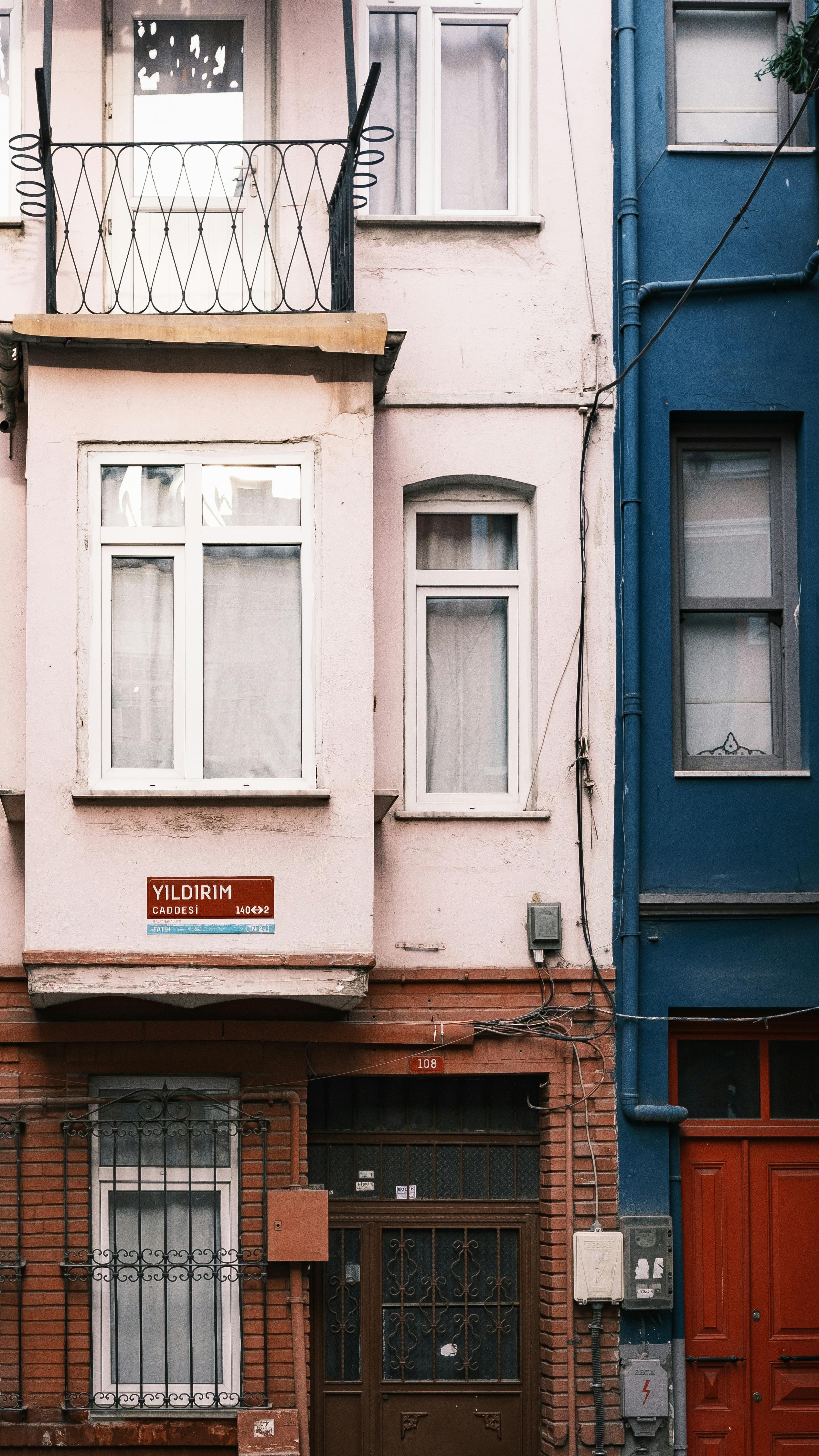 Close-up of vibrant building facades with balconies and street signs, capturing urban character.