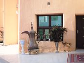 Traditional Arabic coffee set and decor in a sunny Doha courtyard, showcasing Middle Eastern culture.