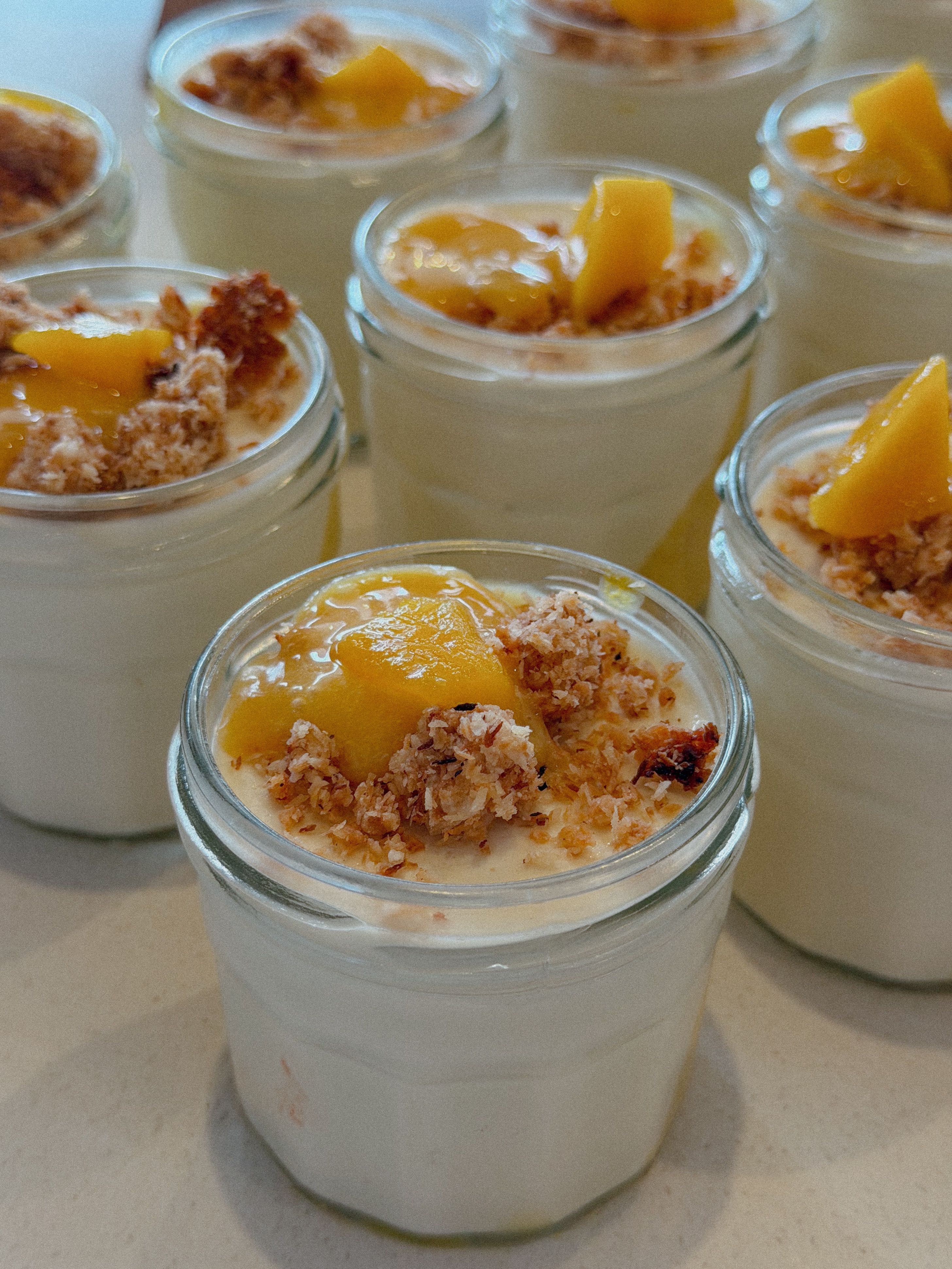 Mango yogurt parfait layered in a glass jar with granola