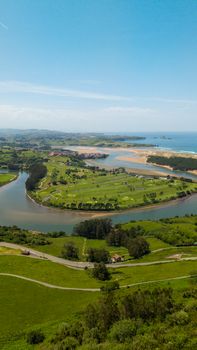 Aerial view capturing the stunning landscape of La Rabia river bend and nearby coastline in Cantabria, Spain.