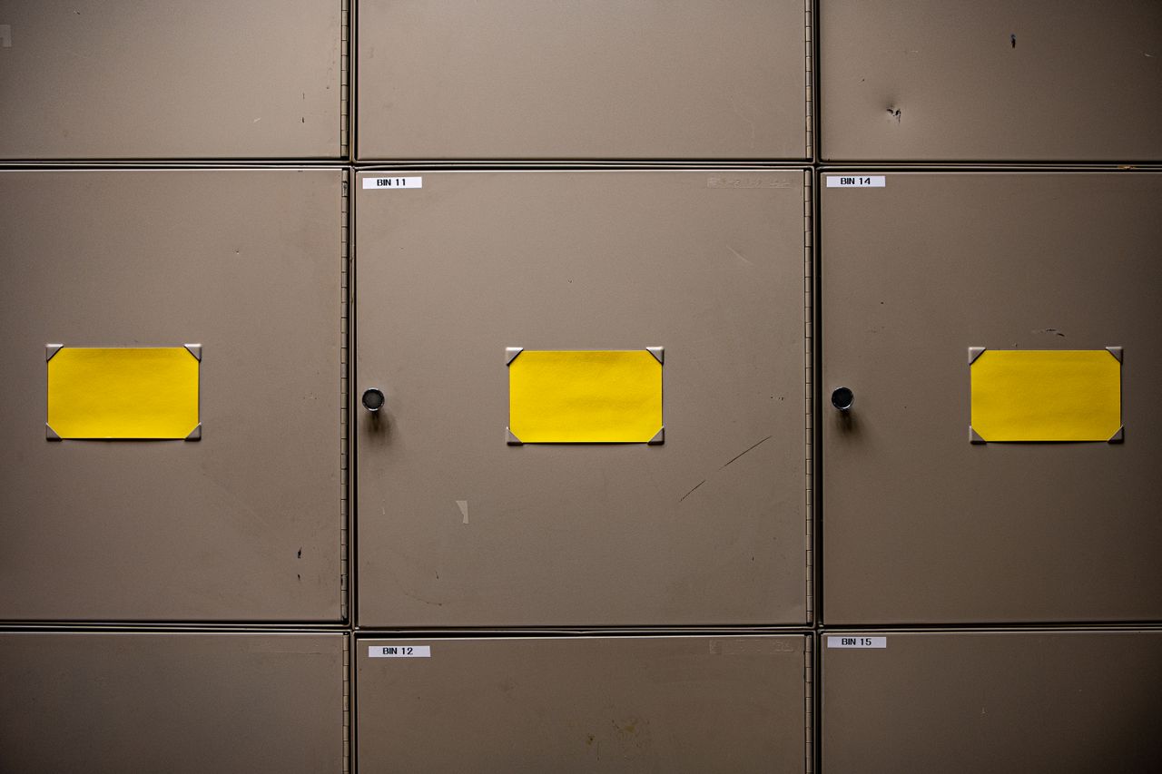 Steel cabinets with yellow labels for organization in an interior setting.