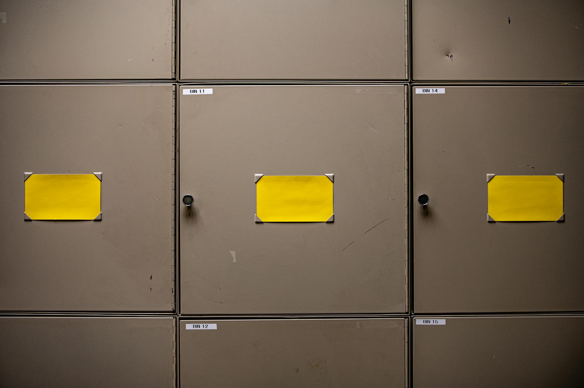 Steel cabinets with yellow labels for organization in an interior setting.