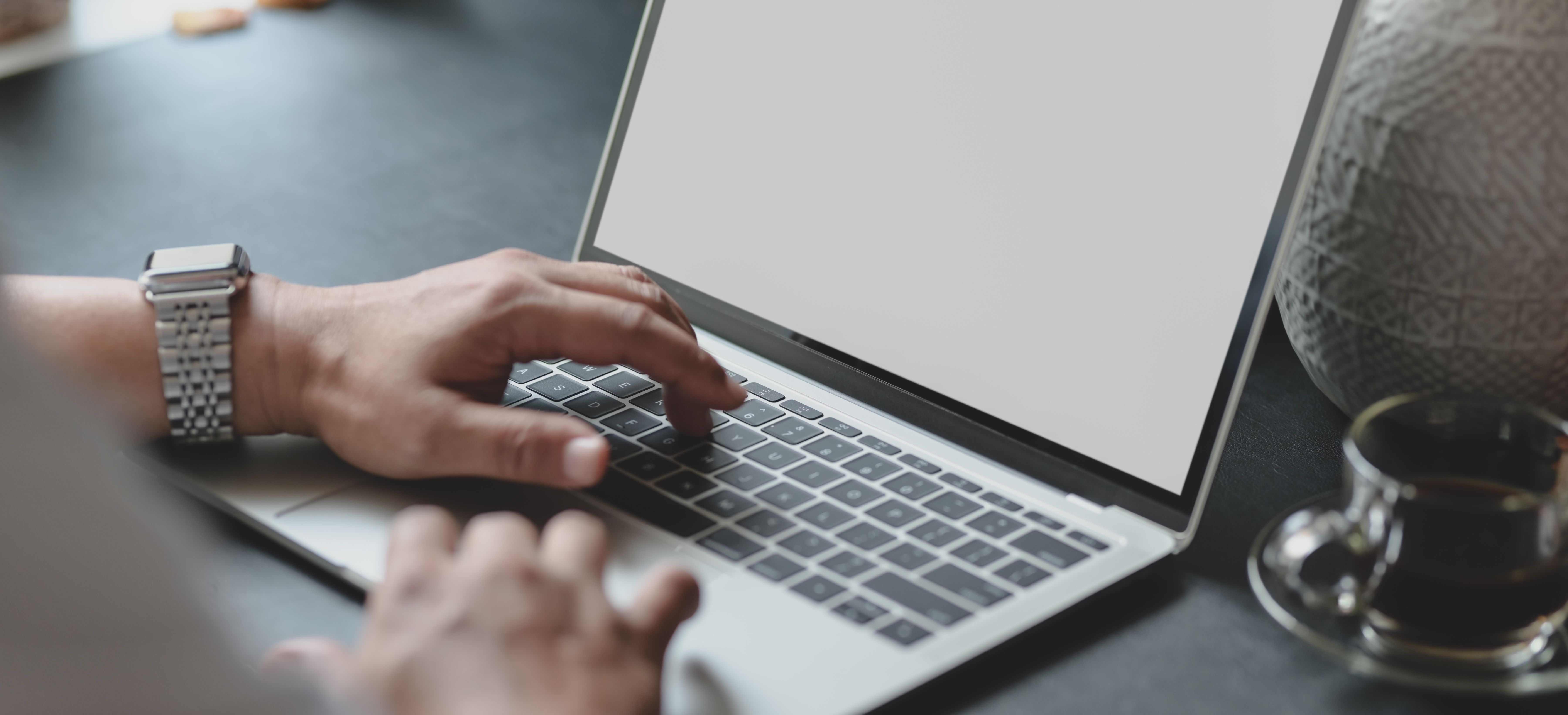 A Cup of Espresso Beside a Man Using Computer Laptop