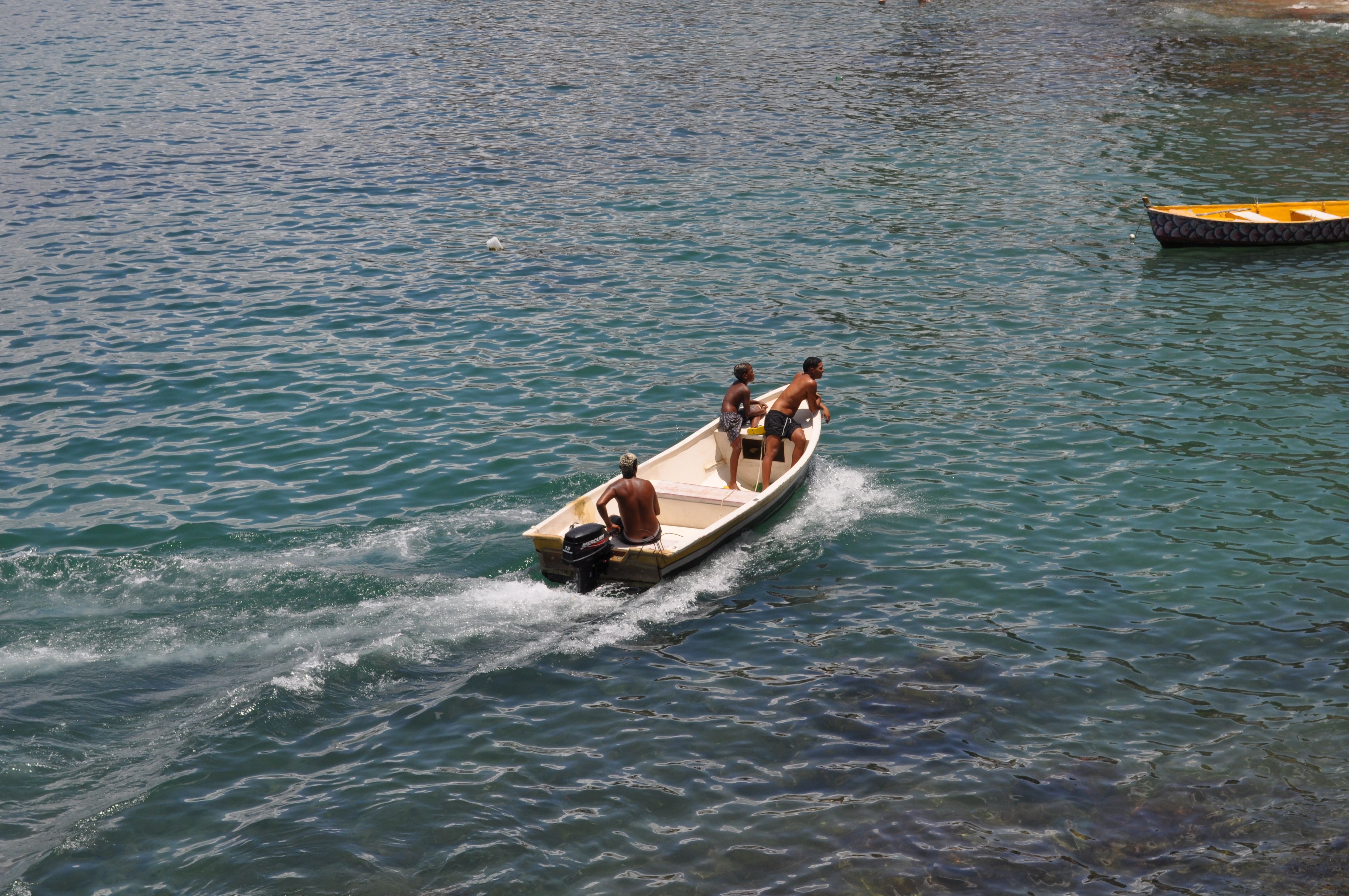 Three Men on a Motorboat in Clear Blue Waters · Free Stock Photo