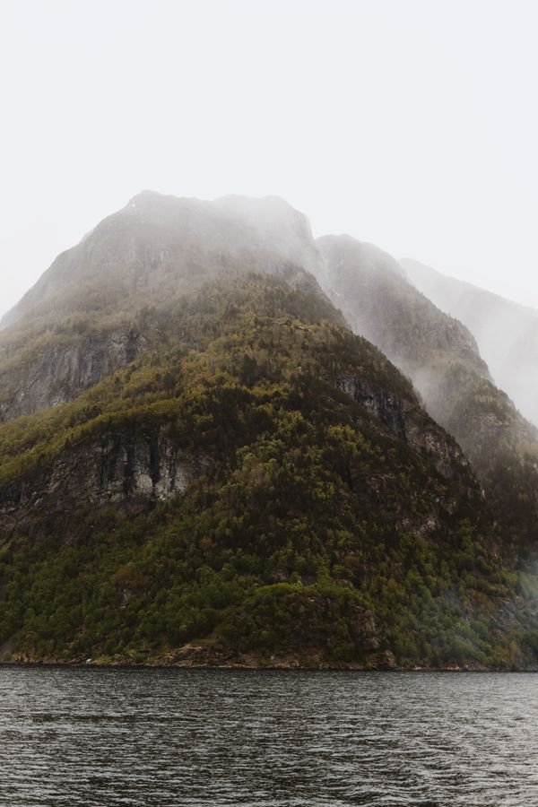 Mist drifting across a steep fjord ridge — photo by Laura Meinhardt on Pexels