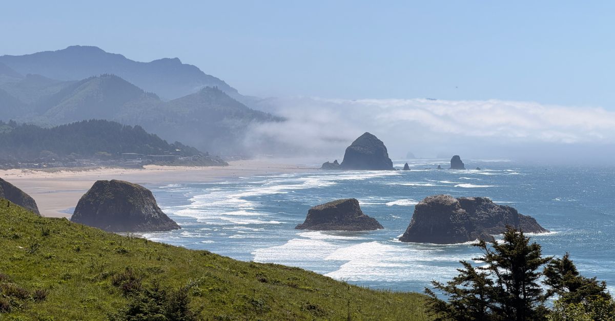 Breathtaking coastal view of Cannon Beach featuring Haystack Rock and vibrant greenery.