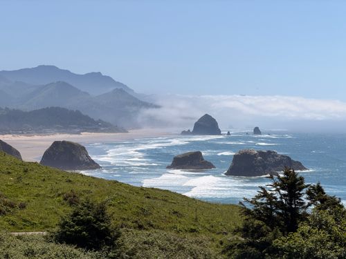 Free Breathtaking coastal view of Cannon Beach featuring Haystack Rock and vibrant greenery. Stock Photo