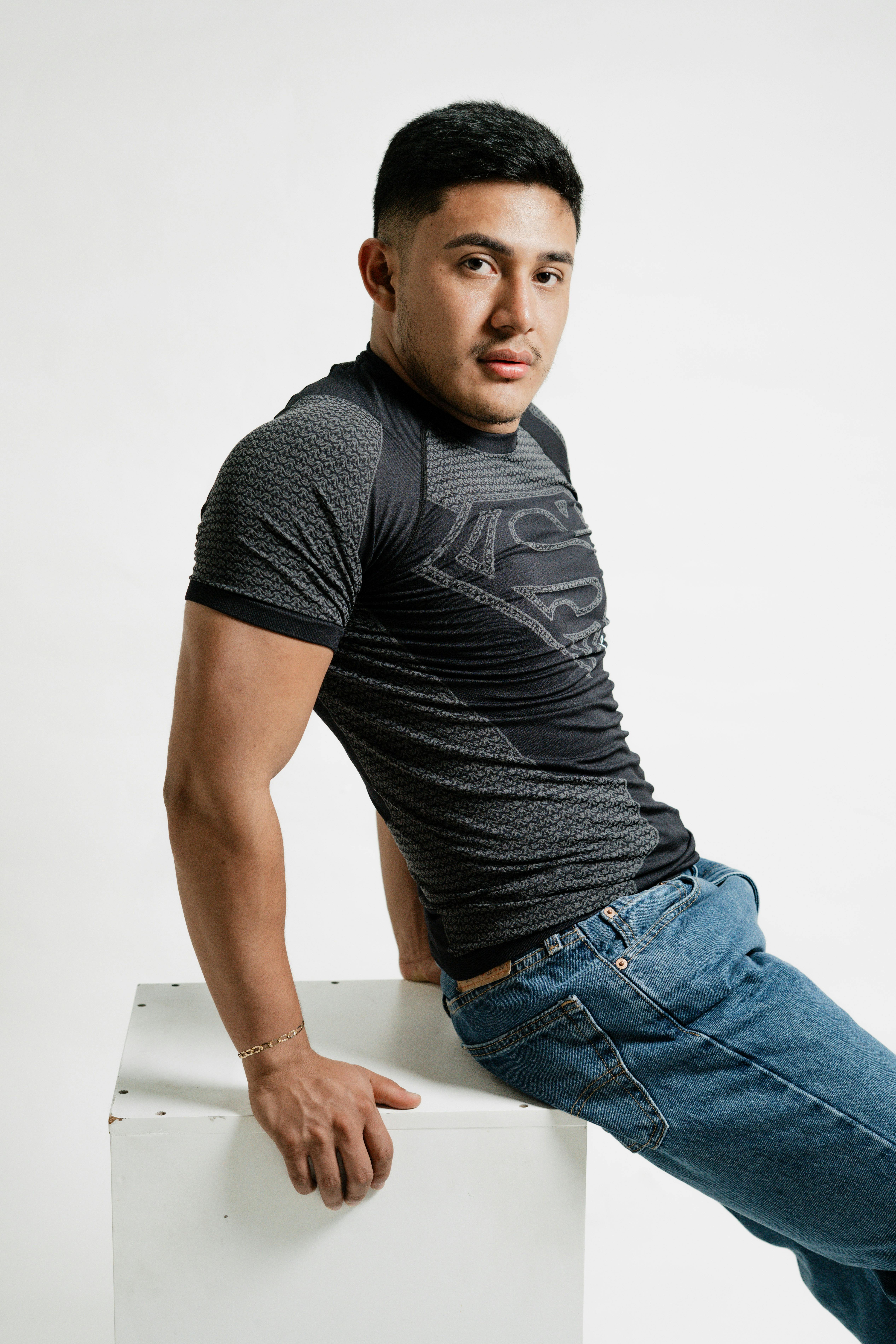 Portrait of a confident young man posing indoors with a modern casual outfit, exuding charm and style.