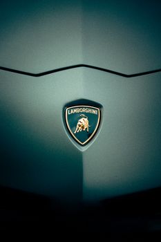 Close-up of a Lamborghini logo on a sleek car hood photographed in Leiria, Portugal.
