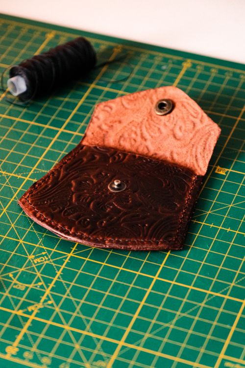 Free Intricately designed leather wallet on a cutting mat, highlighting craftsmanship. Stock Photo
