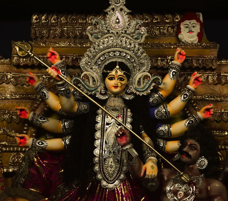 Vivid sculpture of Hindu Goddess Durga slaying Mahishasura at a religious festival.