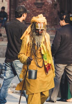 在尼泊尔加德满都，一位身着五颜六色长袍的传统萨杜正走过一条熙熙攘攘的街道