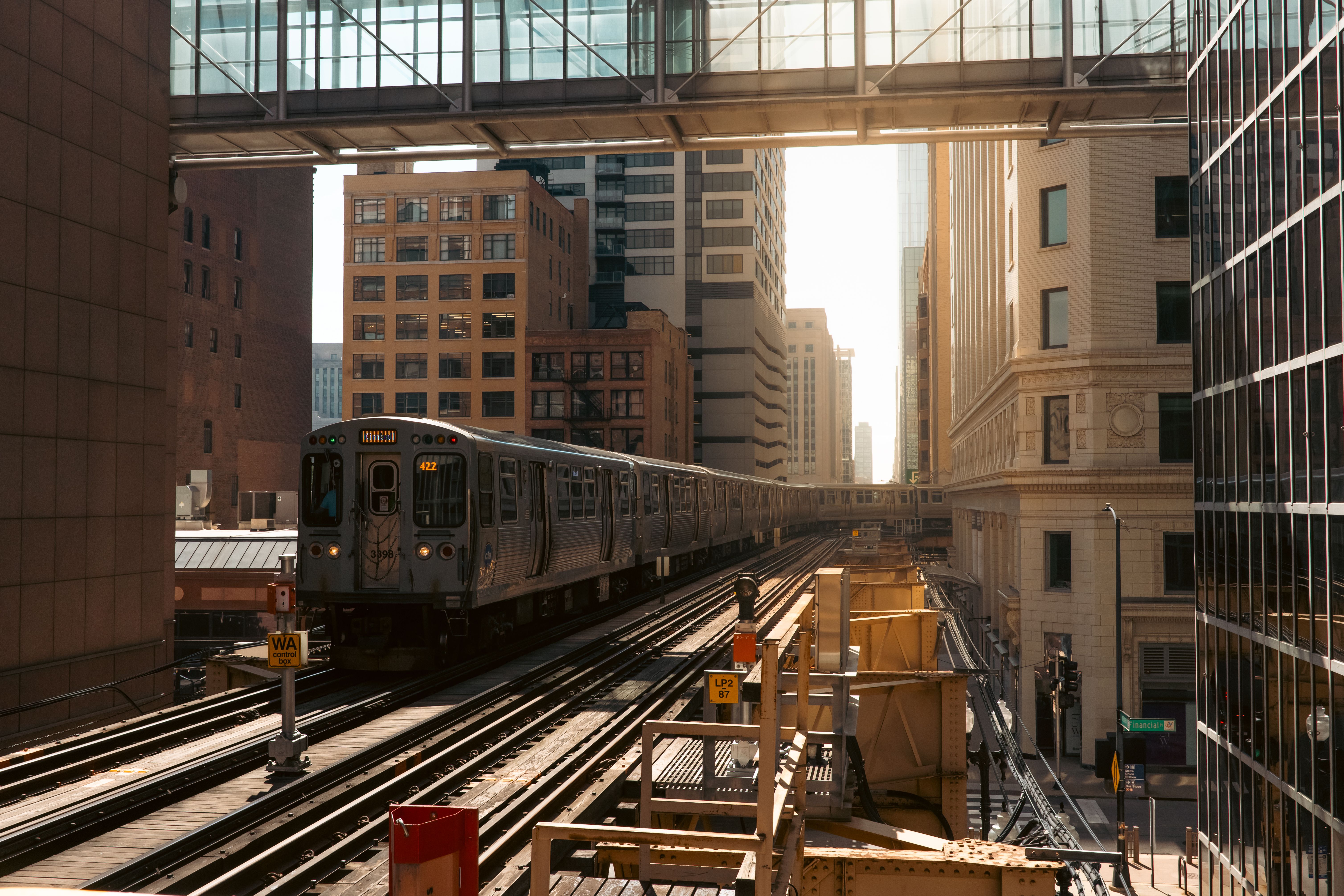 Chicago elevated train in the Loop district during daylight, surrounded by skyscrapers.