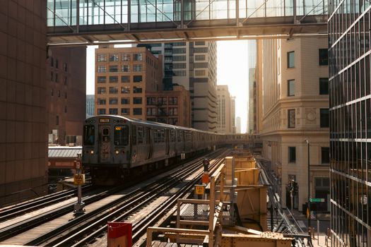 Chicago elevated train in the Loop district during daylight, surrounded by skyscrapers.