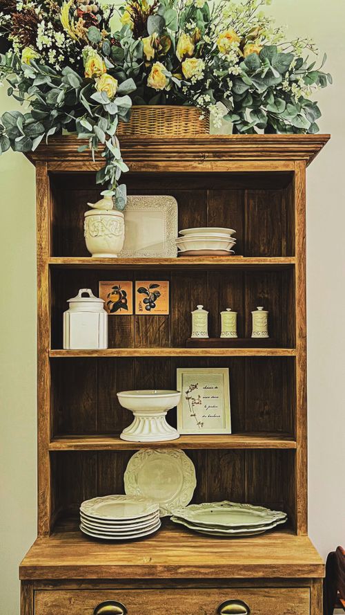 Free A stylish wooden shelf adorned with elegant ceramics and floral decor. Stock Photo