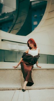 Fashionable woman poses elegantly in a modern architectural setting. Urban chic and style.