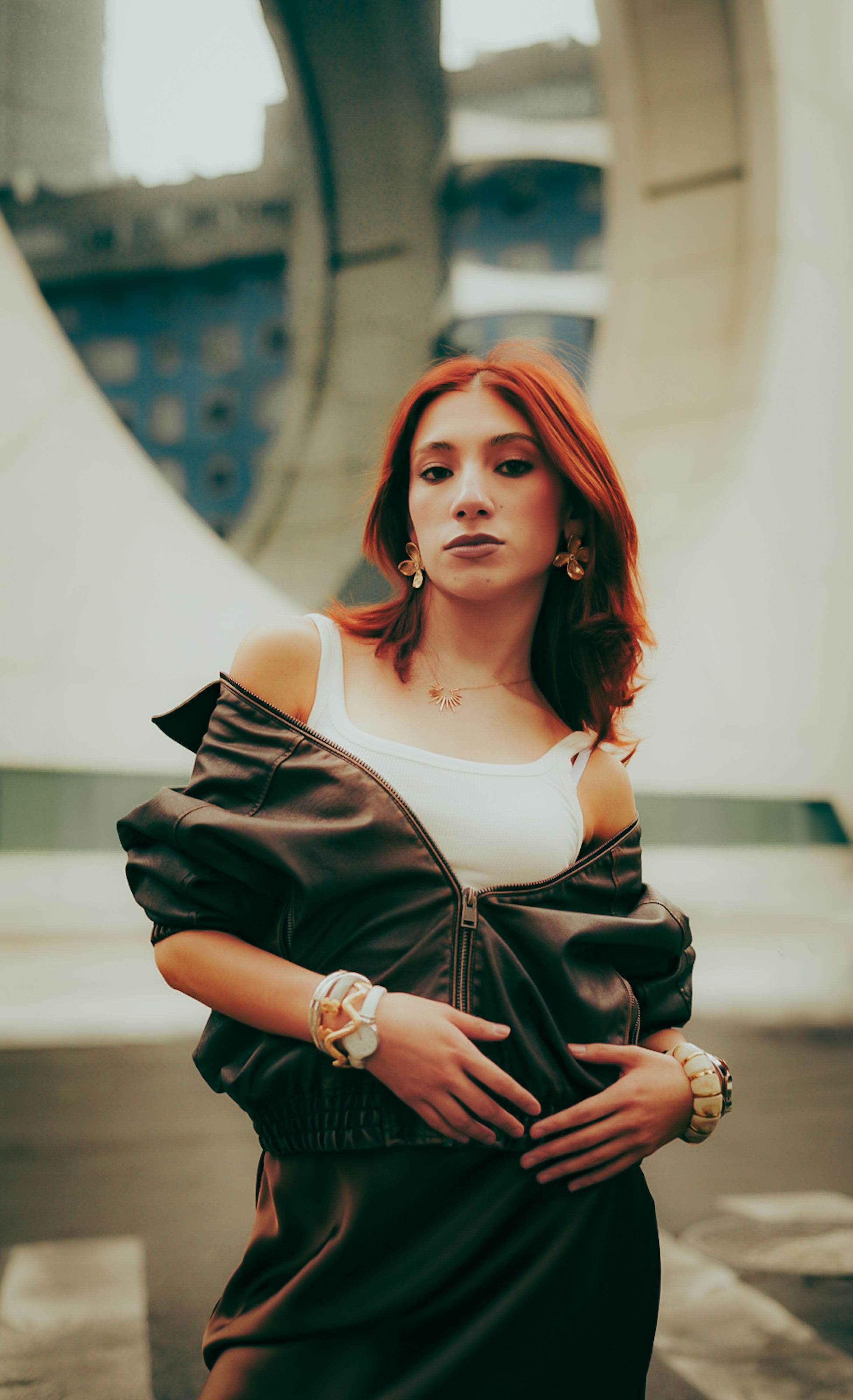 Mulher estilosa em ambiente urbano, exibindo moda moderna com um cenário arquitetônico icônico.