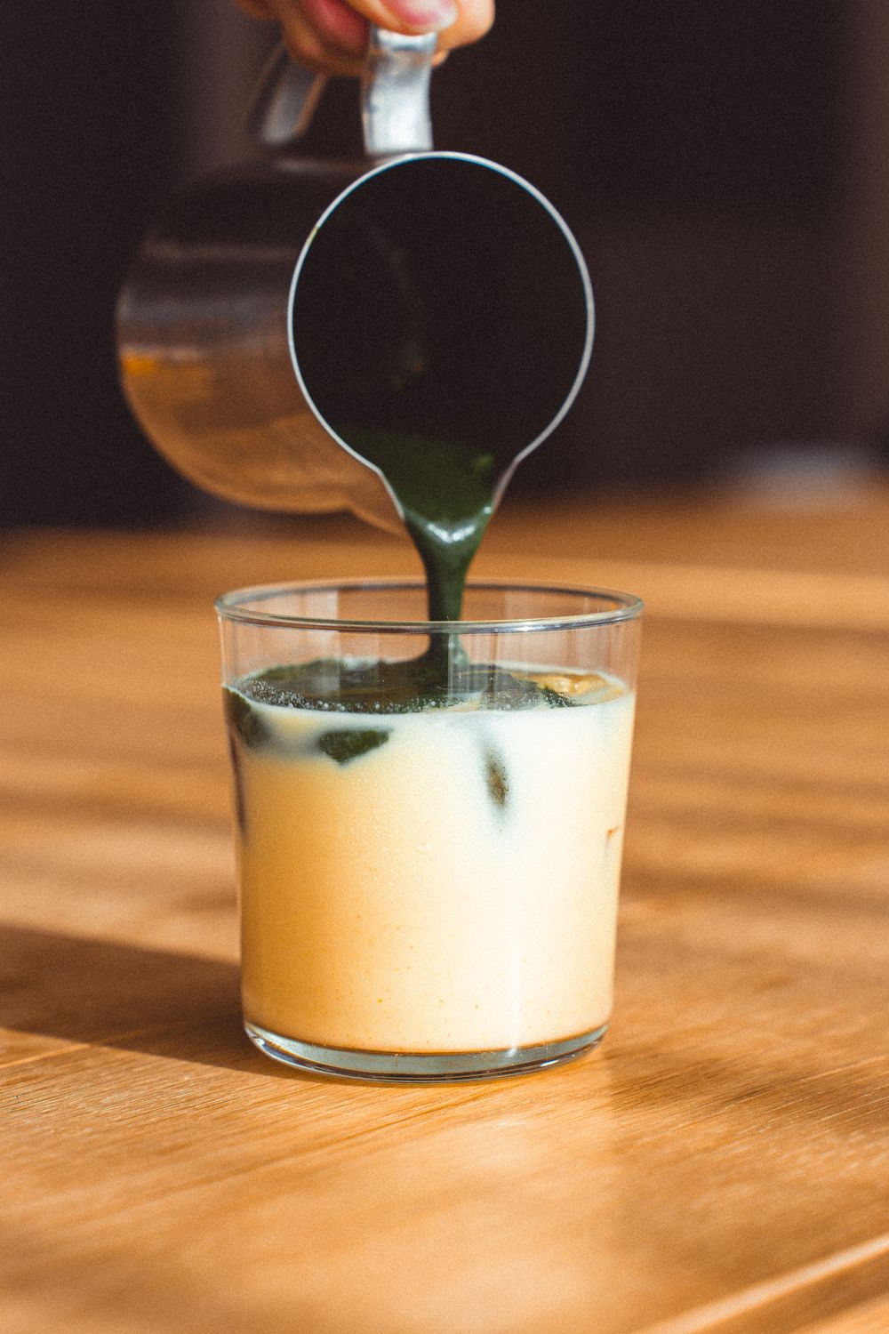 Matcha poured over iced oat milk, photo by Szymon Shields on Pexels