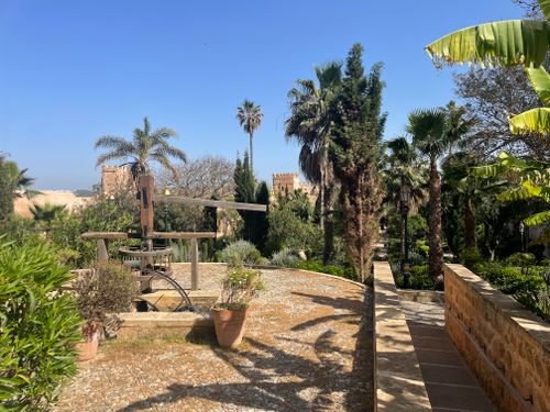 Free Beautiful garden scene with palm trees and historic architecture in Rabat, Morocco. Stock Photo