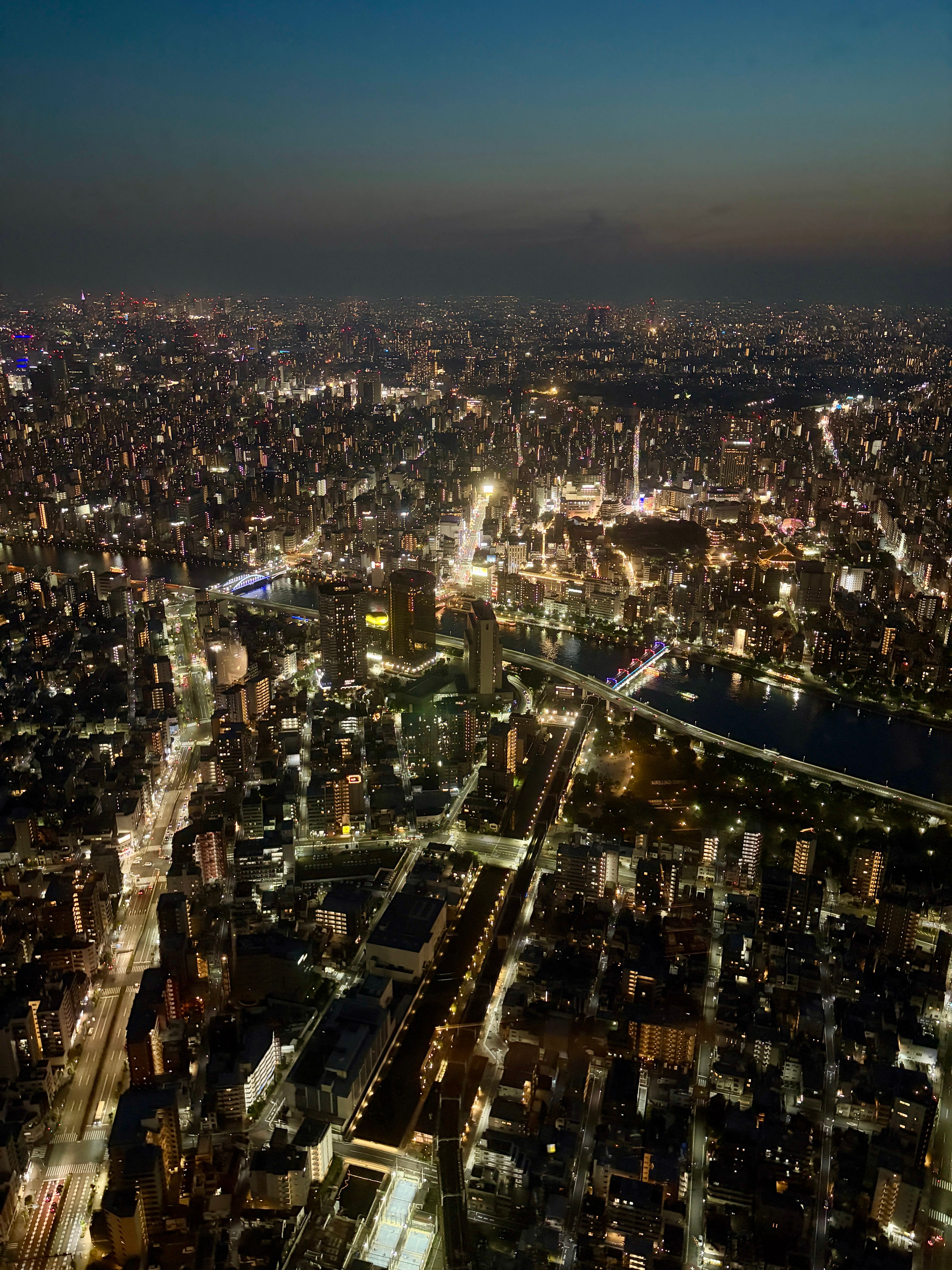 Aerial view of Tokyo's vibrant city lights and bustling urban landscape at night.