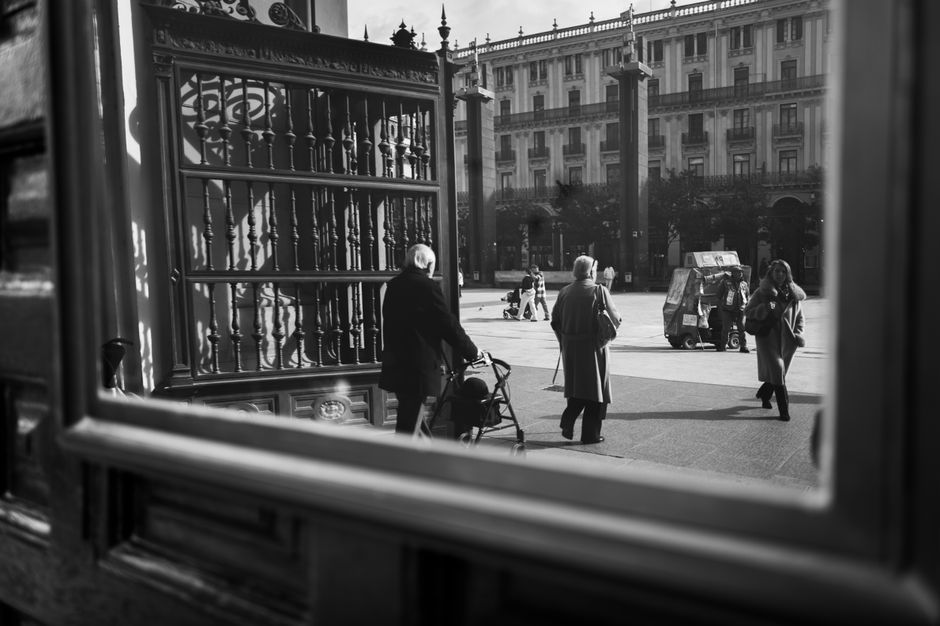Vista en monocromo de la calle de la ciudad a través de la ventana con peatones caminando en invierno.
