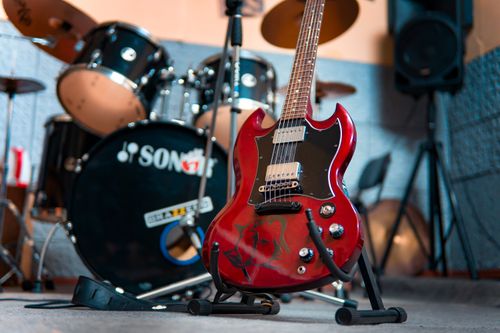 Free From below of modern electronic shiny guitar against drum kit and speakers in music studio Stock Photo