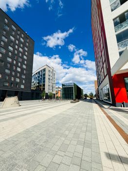 Vibrant cityscape featuring modern buildings under a bright blue sky.