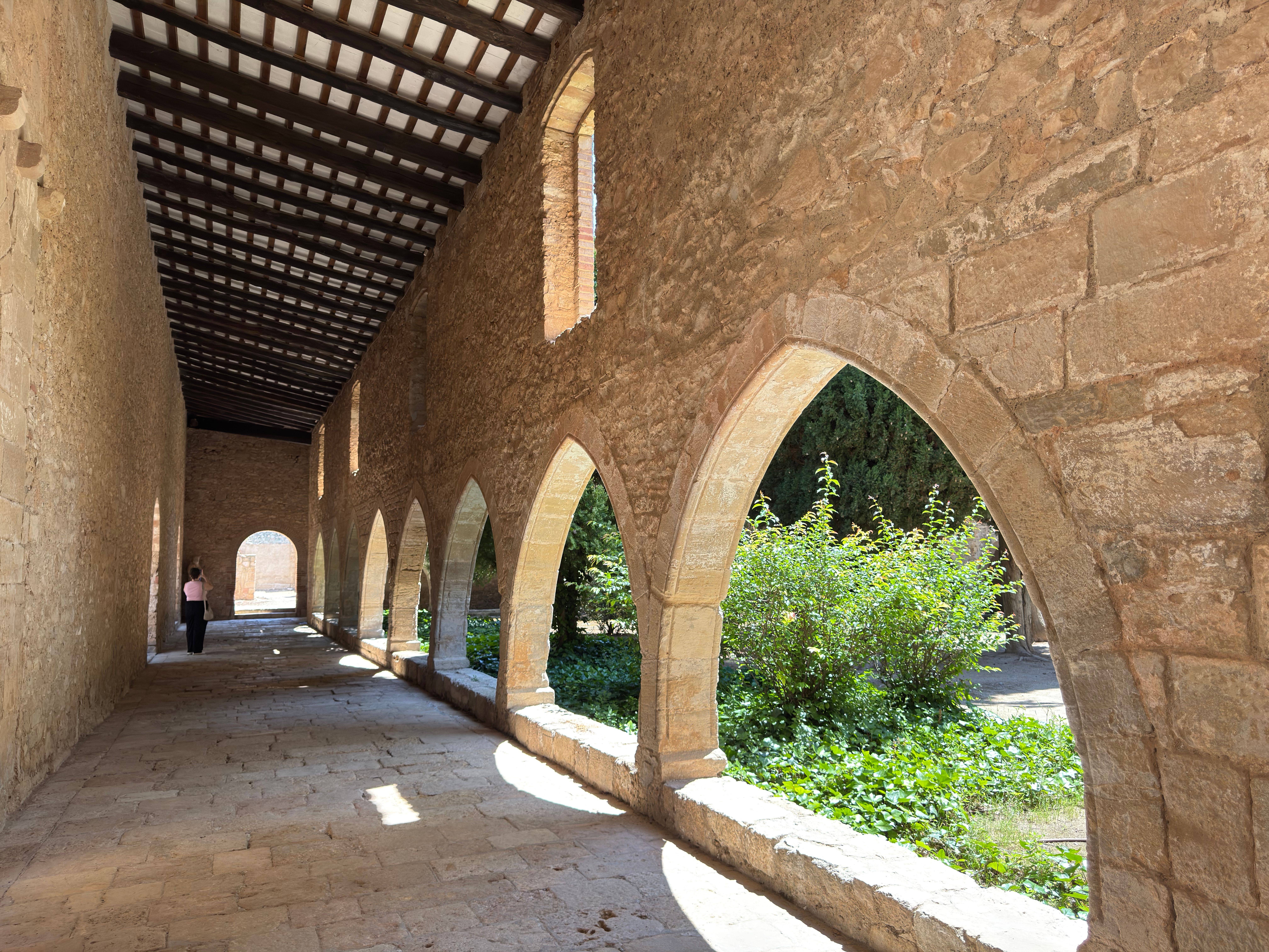 Sunlit arched stone cloister at Santes Creus Monastery, Catalonia, Spain.