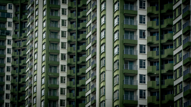 Close-up view of high-rise apartment facade with green accents.