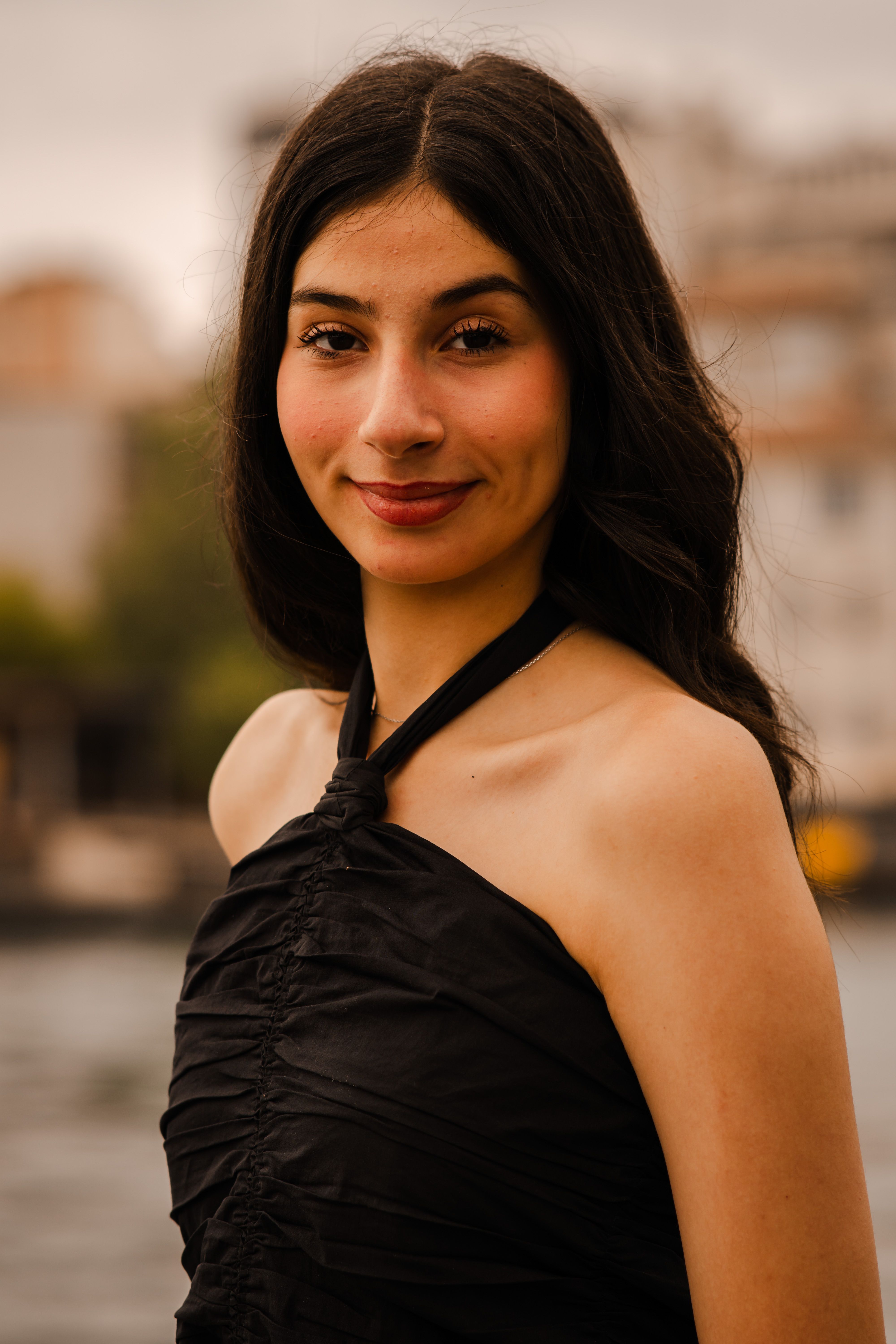 Elegant portrait of a woman wearing a black dress near the Bosphorus in Istanbul.