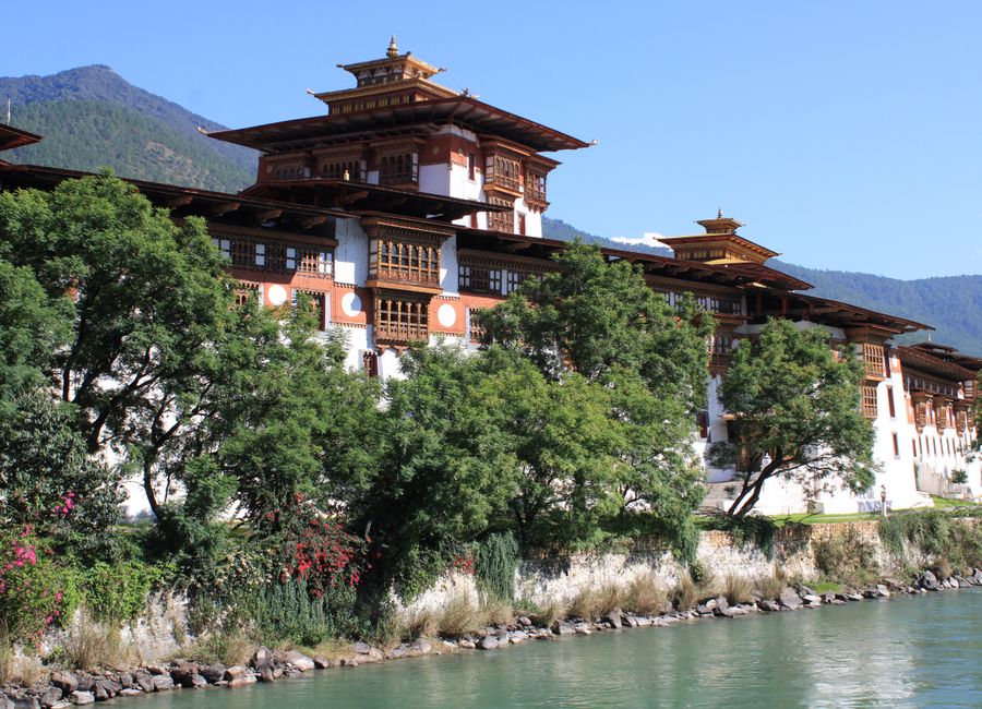 Scenic view of Punakha Dzong along a river with lush greenery in Bhutan.
