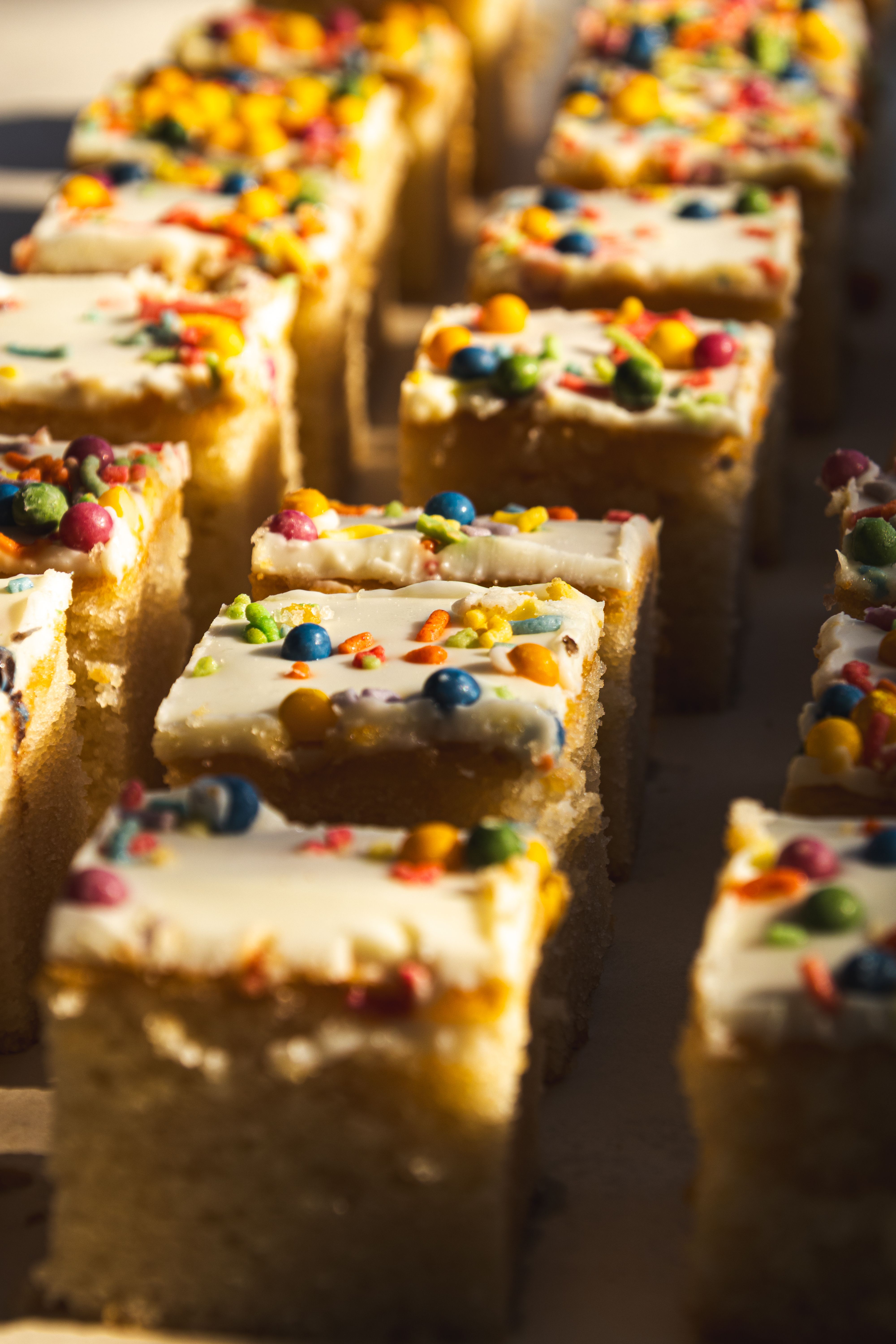 Colourful sprinkle-topped cake squares in the sun