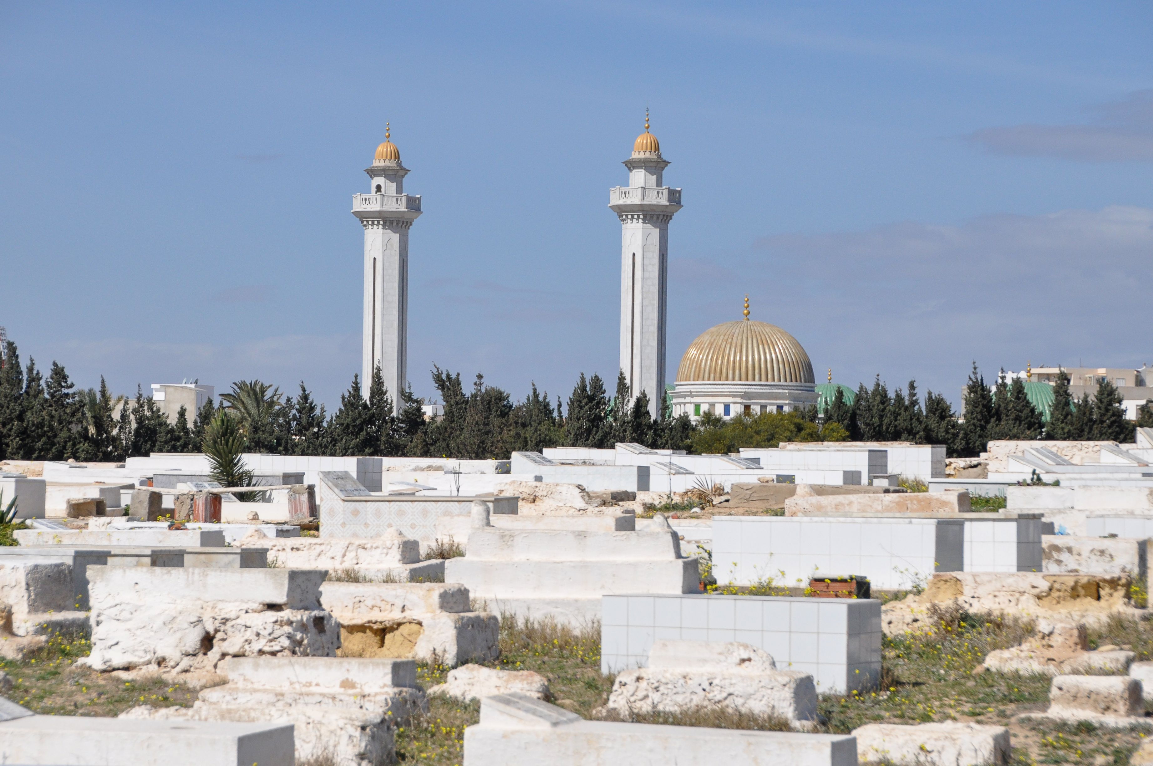 Bourguiba Mausoleum with its golden dome and cemetery in Tunis, Tunisia under a clear blue sky.