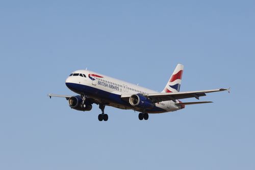 Free British Airways Airbus A320 jet flying against clear blue sky. Stock Photo