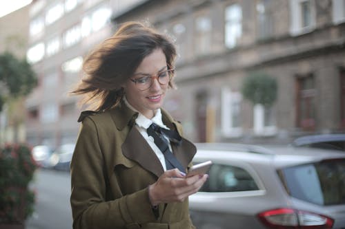 Elegante Femmina Adulta Utilizza Lo Smartphone Sulla Strada