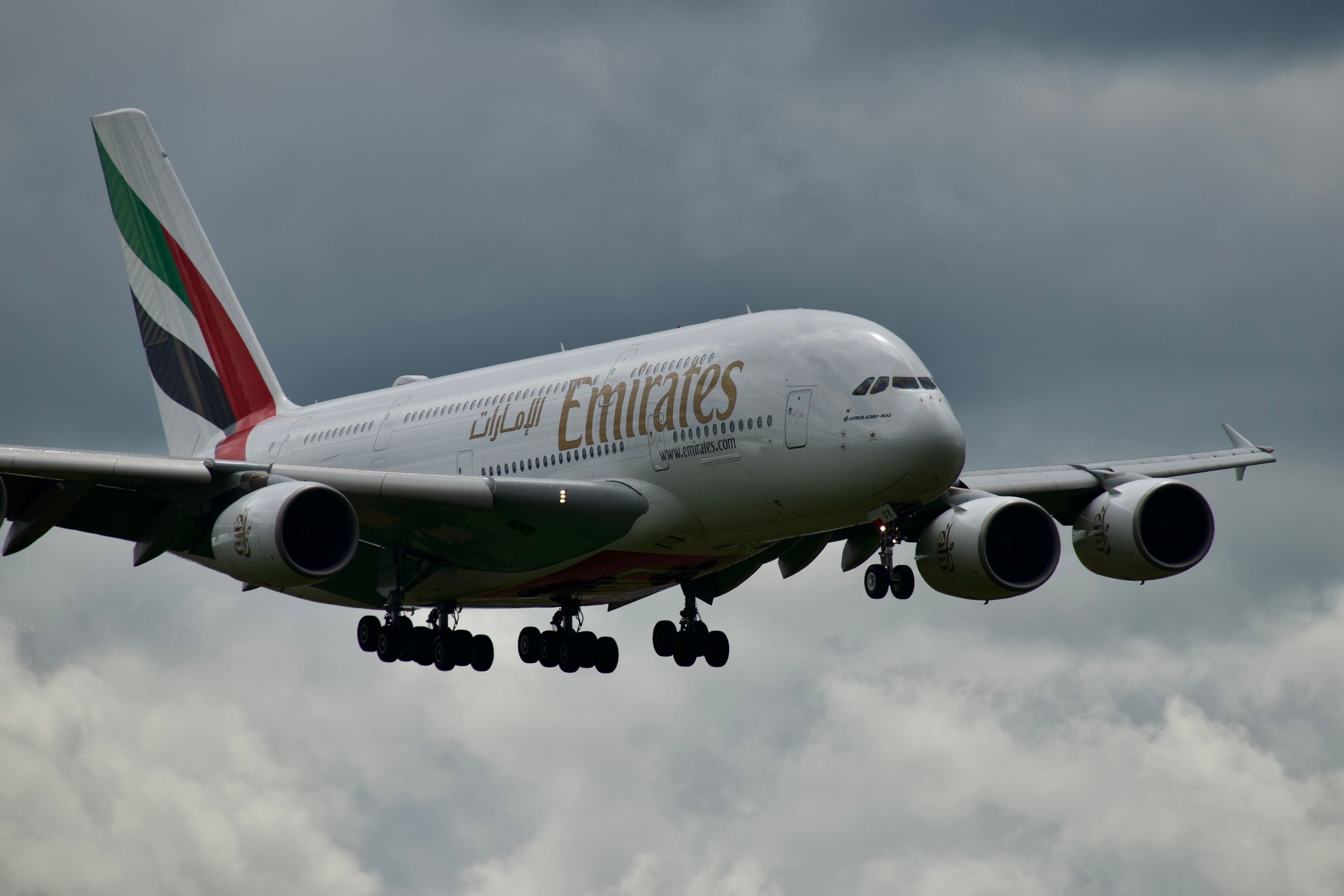 Emirates Airbus A380 airplane flying against a cloudy sky, showcasing aviation prowess.