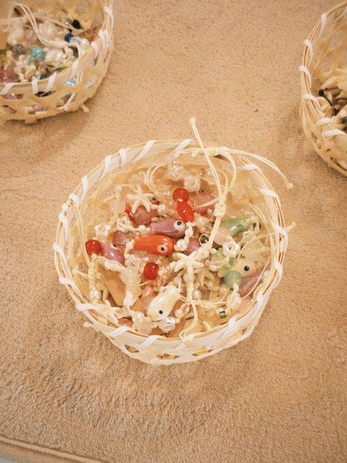 Free Colorful beaded jewelry in a woven basket, showcasing intricate detail and craftsmanship. Stock Photo