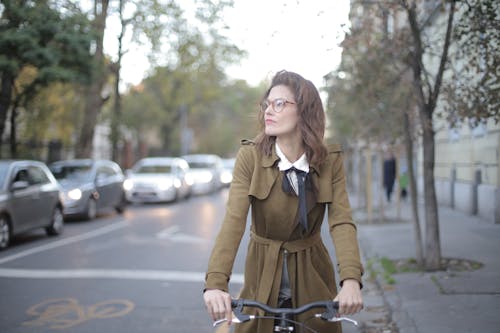 Bicicleta Negra Impulsada Por Una Mujer Vestida Con Abrigo Marrón